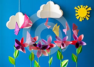 Origami paper flowers, butterflies, clouds and sun.