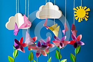 Origami paper flowers, butterflies, clouds and sun.