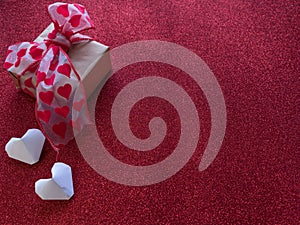 Origami paper hearts make up symbols for Valentine`s Day, with gift box with red hearts gift ribbon.