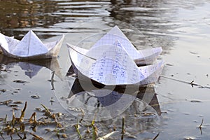 Origami paper ships sailing in river.