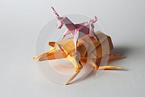 Origami unicorn riding origami bug