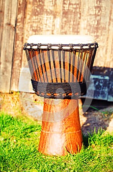 Original african djembe drum with leather lamina, on green in sun light