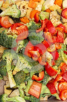 An original background of finely chopped and seasoned vegetables before baking in the oven. Potatoes, bell peppers, squash,