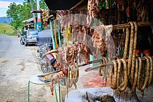 Original Caribbean food on the roadside in the Dominican Republic. Smoked pork, morcillas and longanizas.