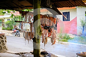 Original Caribbean food on the roadside in the Dominican Republic. Smoked pork, morcillas and longanizas.