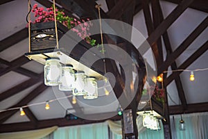 Original chandelier from jars and a flowerpot with flowers