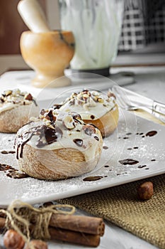 Original cinnabon rolls with chocolate-cream sauce and hazelnuts