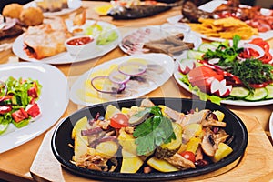 Original fajita sizzling smoking hot served on iron plate and fresh vegetables on background.