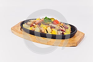 Original fajita sizzling smoking hot served on iron plate and fresh vegetables on background.