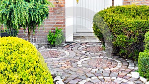 Original garden path with circular paving close-up. Pathway from brick paving stones made of red and white granite. Creative
