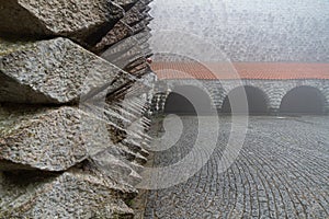 Original granite faÃ§ade of the bell tower of the Sanctuary of Aranzazu under the fog.