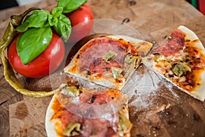 Original Italian Pizza alla diavolo on brown wood background. Pizza with Hot peppers and salami close up