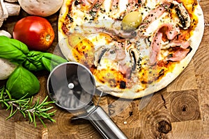 Original Italian Pizza con funghi on brown wood background. Pizza with ham and mushrooms close up