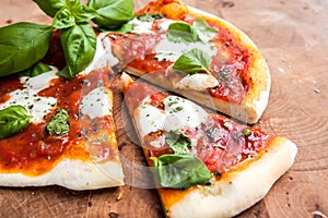 Original Italian Pizza Margherita on brown wood background. Pizza Margarita with Tomatoes, Basil and Mozzarella Cheese
