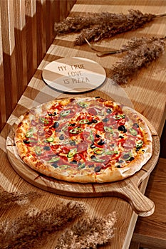 Original neapolitan pizza margherita on a traditional wooden plate , Italy. Pizza with olives.Wooden background, top view