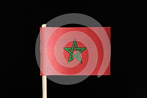 A original and official flag of Morocco on toothpick on black background. Consists of a red field with the green pentagram, a five