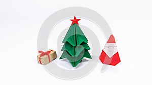 Original origami Christmas holiday card. Christmas tree, gift box and Santa Claus folded from paper