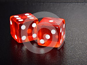 Original Red Casino Gambling Dice on Black Textured Reflecting Background