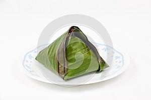 Original single traditional nasi lemak wrapped in banana leaf served on plate.