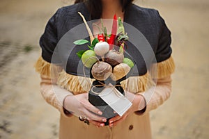 The original unusual edible vegetable and fruit bouquet with card in girl hands