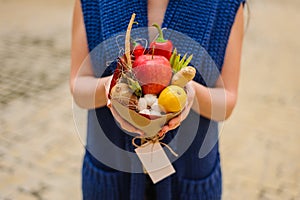 The original unusual edible vegetable and fruit bouquet in girl hands