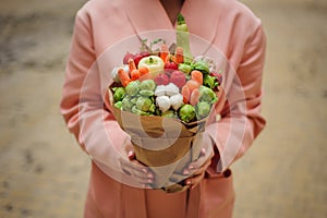 The original unusual edible vegetable and fruit bouquet in woman hands