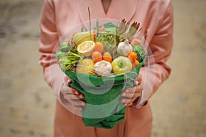 The original unusual edible vegetable and fruit bouquet in woman hands