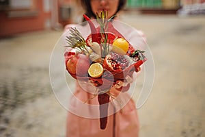 The original unusual edible vegetable and fruit bouquet in woman hands