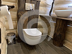 Original wooden bathroom design. Wall-mounted toilet in a wooden house