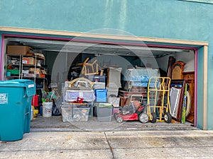 An unorganized garage filled with a lot of stuff in a neighborhood