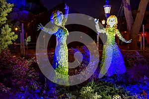 Frozen Elsa and Ana illuminated topiaries on beautiful scenery at Epcot in Walt Disney World