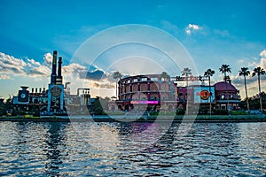Hard Rock Cafe on sunset background at Universal Orlando Resort in Florida with the lake on the foreground.  3