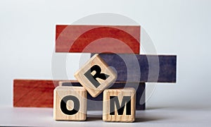 ORM - acronym on wooden cubes on a background of colored block on a light background