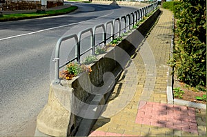 Ornamental flower pots next to the road to the square. ornamental perennial flowers grass. block shape flower pot made of wood mat