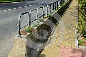 Ornamental flower pots next to the road to the square. ornamental perennial flowers grass. block shape flower pot made of wood mat