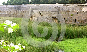 Ornamental old stone wall of vellore fort with grass field