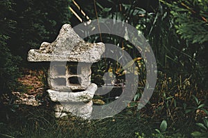 Ornamental stone lantern with moss on the top in zen garden