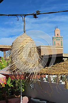 Ornamental straw lamp and umbrela in a terrace in Marrakech