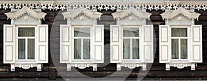 Ornamental windows with carved frames on old wooden rural house in Irkutsk city. Russian folk style in architecture