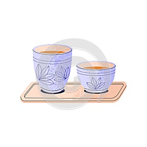 Ornamented pottery cups of green tea. Asian herbal drink in ceramic mugs. Teacups of oolong, puer on tray. Traditional