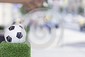 Ornaments of city streets in the form of the classic football ball in the net on the green grass. Decorative stand