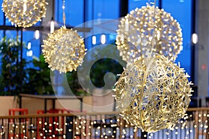 Ornaments and lights in the shopping center. Christmas decorations on the holiday. Colorful balls garland glowing lamps.