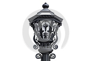 Ornate black lamppost against a white wall. The lamppost features intricate scrollwork and a decorative finial photo