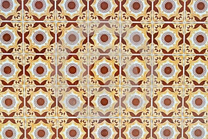 Ornate brown and yellow ceramic tile pattern