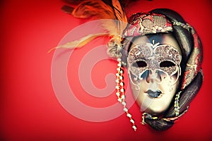 Ornate carnival mask over red background