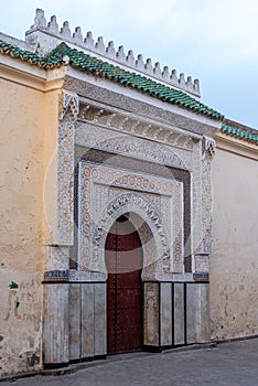 Ornate entrance with wooden carvings and stucco to a mosque in Fes