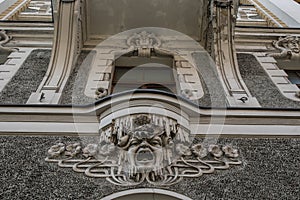 Ornate facade of a house with a head of a man in art nouveau style in Riga, Latvia