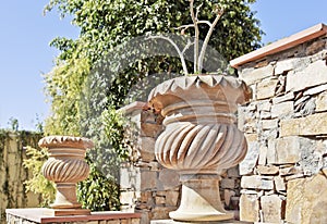 Ornate flower clay pots feature stone wall