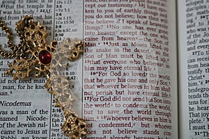 Ornate gold cross on open Bible