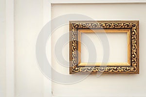 Ornate gold picture frame on a white wall background